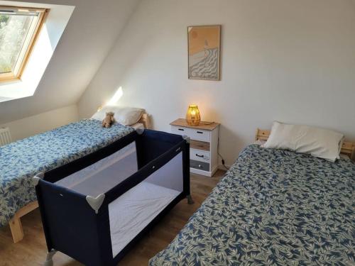 une chambre avec deux lits jumeaux et une commode dans l'établissement Coup de coeur à Pors Carn, à Penmarcʼh