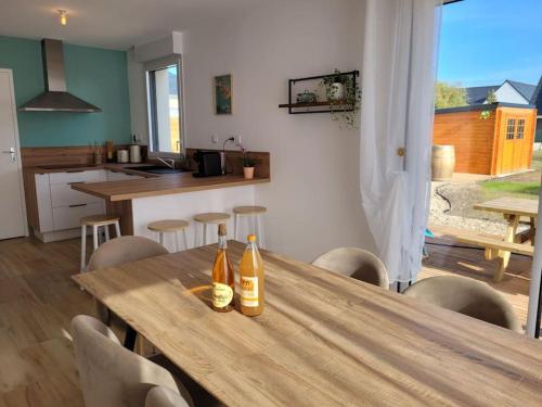 - deux bouteilles de vin sur une table en bois dans la cuisine dans l'établissement Coup de coeur à Pors Carn, à Penmarcʼh
