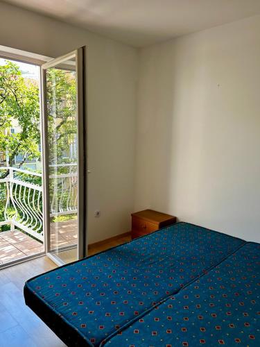 a bedroom with a blue bed and a sliding glass door at Apartman Vera in Selce
