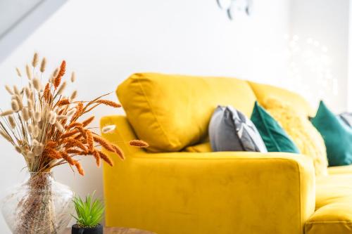 a yellow couch with pillows in a living room at Captivating 2-Bed House in Nettleham in Lincoln
