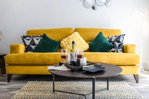a living room with a yellow couch and a table at Captivating 2-Bed House in Nettleham in Lincoln
