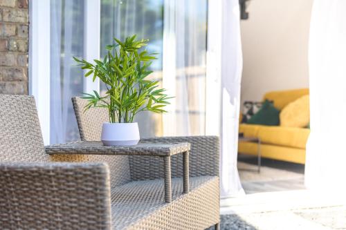 a potted plant sitting on a table next to a chair at Captivating 2-Bed House in Nettleham in Lincoln