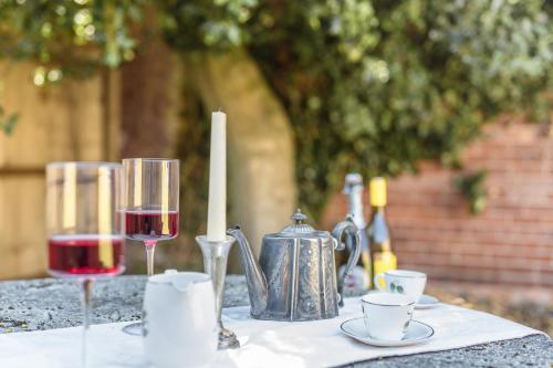 a table with two glasses of wine and a teapot at Captivating 2-Bed House in Nettleham in Lincoln