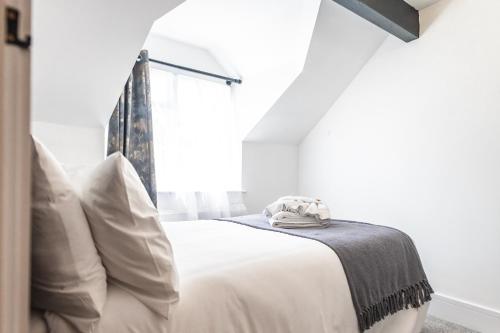 a white bedroom with a bed and a window at Captivating 2-Bed House in Nettleham in Lincoln