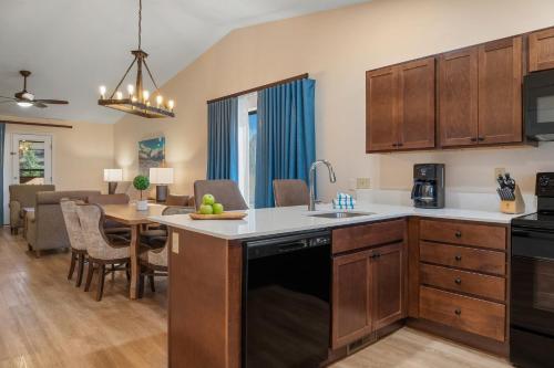 a kitchen with wooden cabinets and a dining room at Club Wyndham Pagosa in Pagosa Springs