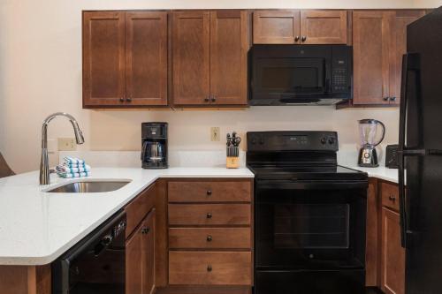a kitchen with a black stove and a sink at Club Wyndham Pagosa in Pagosa Springs