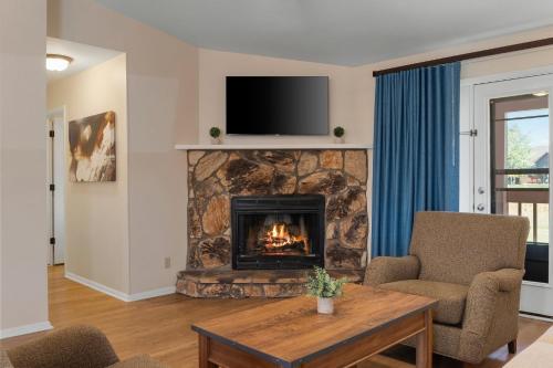 a living room with a fireplace with a tv above it at Club Wyndham Pagosa in Pagosa Springs