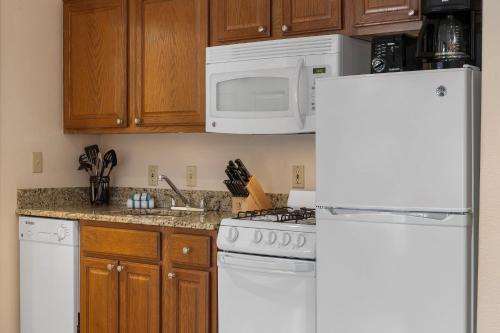 a kitchen with a white refrigerator and a white microwave at Club Wyndham Pagosa in Pagosa Springs