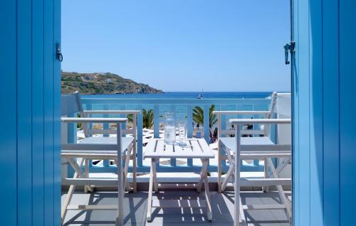 a table and chairs on a balcony with a view of the ocean at Blue Harmony Hotel in Kinion