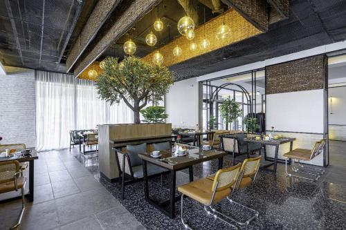 a restaurant with tables and chairs in a room at Ewaa Express Hotel - Al Jouf in Sakakah