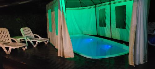 a green room with a tub and two chairs at Cabañas Rancho Unelen in Colón