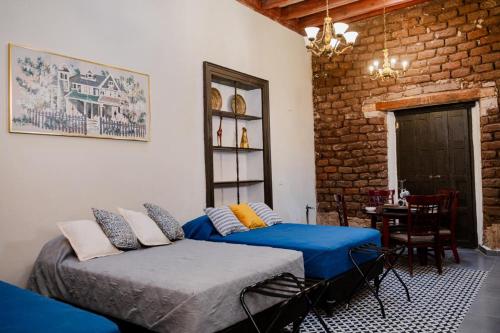 a bedroom with two beds and a brick wall at Hotel Boutique Casona los Pavorreales in Durango