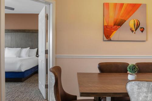 a hotel room with a bed and a room with a table at Club Wyndham Pagosa in Pagosa Springs
