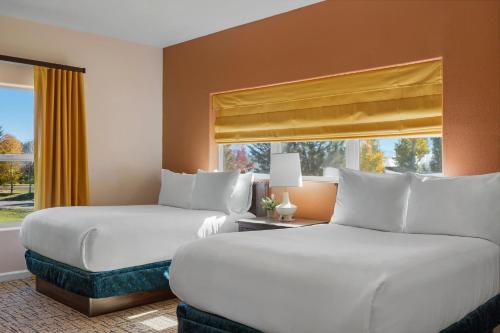 two beds in a hotel room with a window at Club Wyndham Pagosa in Pagosa Springs