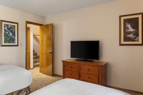 a bedroom with a television on a dresser with a bed at Club Wyndham Pagosa in Pagosa Springs