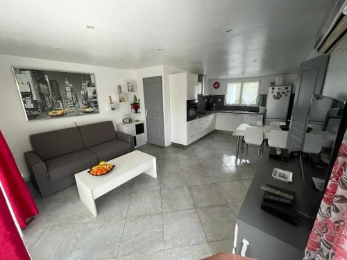 un salon avec un canapé et une cuisine dans l'établissement Jolie maison avec jardin, à Hyères