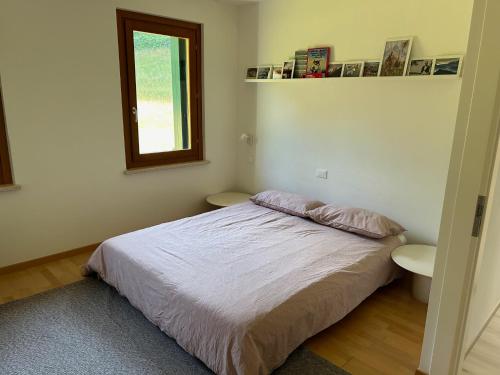 a small bedroom with a bed and a window at Fastuc B&B in Ponte nellʼAlpi