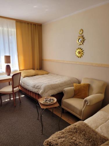 a bedroom with a bed and a chair and a table at Pokoje Gościnne u Stasi in Mielno