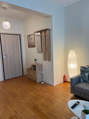 a living room with a couch and a wooden floor at Acropolis Sidewalk view in Athens