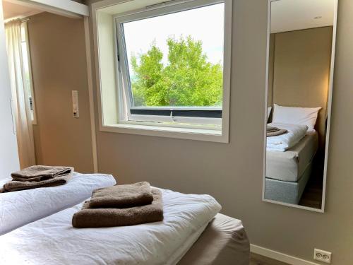 a room with two beds and a mirror and a window at Cozy Central Apartment in Ålesund in Ålesund