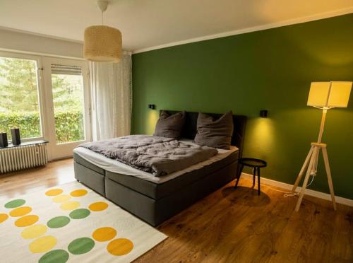 a bedroom with a green wall and a bed at Ferienhaus 'Emma' Rodalben in Rodalben