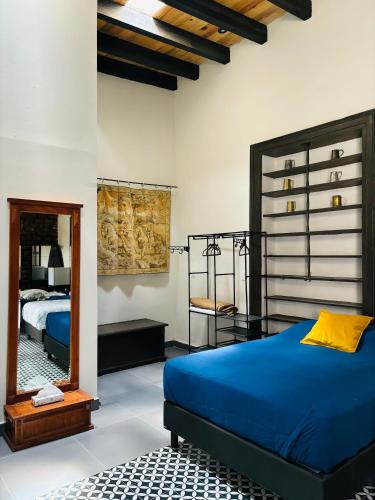 a bedroom with a blue bed and a mirror at Hotel Boutique Casona los Pavorreales in Durango