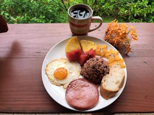 a plate of breakfast food with a cup of coffee at Ana Paraíso entre Arboles in Drake