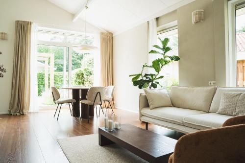 a living room with a couch and a table at Bed en Wellness Groenrust Putten in Putten