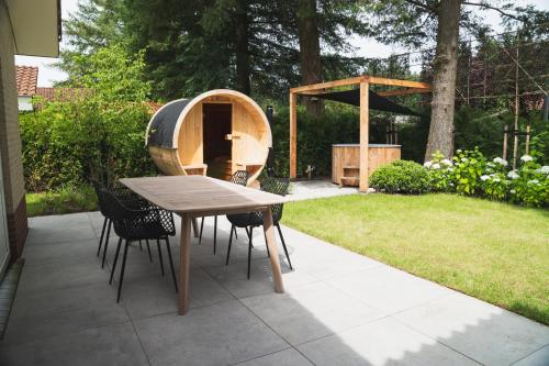 a backyard with a table and chairs and a sauna at Bed en Wellness Groenrust Putten in Putten