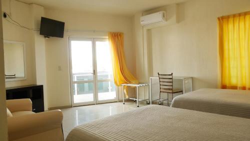 a hotel room with two beds and a window at Hotel Insurgentes Express in Tepic