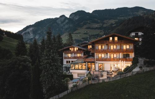a large building on the side of a hill at Genusshotel Fichtenhof in Grossarl