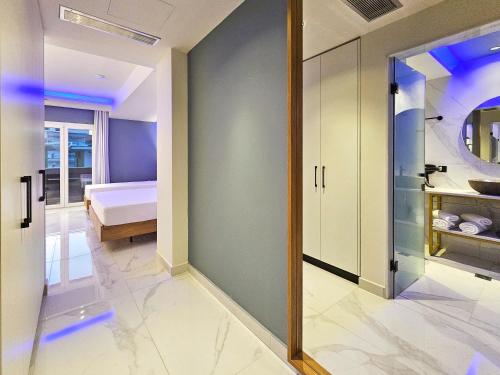 a bedroom with a bed and a hallway with a mirror at AKTEON GIRNI in Paralia Katerinis