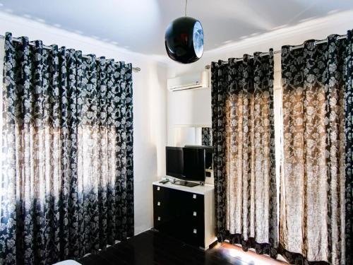 a room with black curtains and a tv and a televisionictericter at Lux Apartment in Vlorë