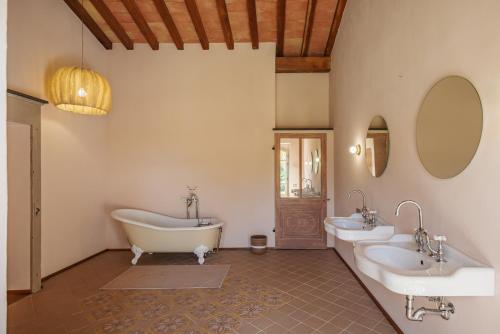 La salle de bains est pourvue de 2 lavabos, d'une baignoire et de miroirs. dans l'établissement Luxueuse Villa - Le paradis Terre et Mer, à Ramatuelle