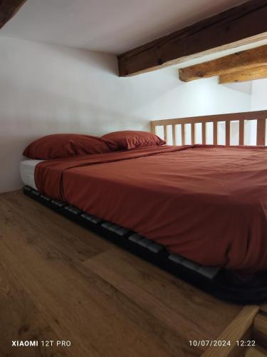 Cette chambre comprend un lit avec des draps rouges et du parquet. dans l'établissement Vieux port, à Marseille