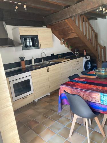 une cuisine avec une table, un évier et une cuisinière dans l'établissement Maison 2 chambres avec cour intérieure, à Alet-les-Bains