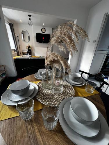 a table with plates and glasses on top of it at Cozy 2 bed house oldham 10 miles to Manchester City centre wifi included in Oldham