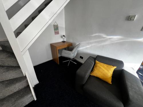 a living room with a couch and a table and stairs at Cozy 2 bed house oldham 10 miles to Manchester City centre wifi included in Oldham
