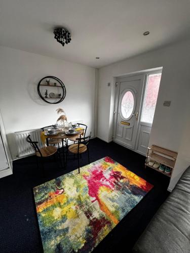 a living room with a table and a colorful rug at Cozy 2 bed house oldham 10 miles to Manchester City centre wifi included in Oldham