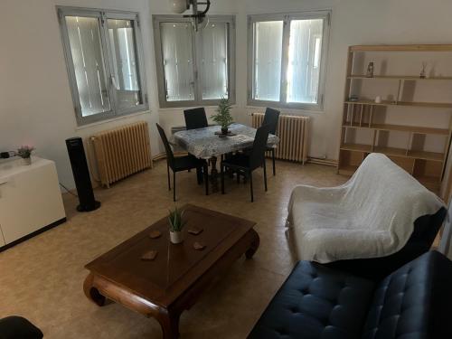 un salon avec une table et des chaises dans l'établissement Chambre privée dans Maison d'hotes 10 minutes à pied de la gare et du centre, à Alès