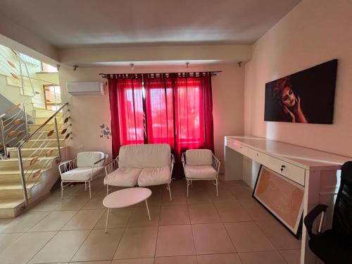 a living room with a red window and chairs at Pensiunea Casa Copou in Iaşi