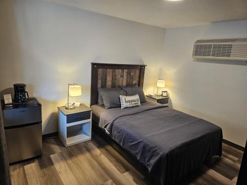 a bedroom with a bed and two night stands and two lamps at Harbor View Inn Tawas in Tawas City