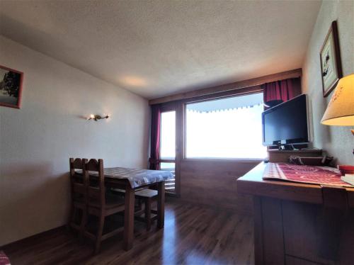 Cette chambre dispose d'une table et d'un bureau avec un ordinateur. dans l'établissement Résidence Chamois - Studio pour 4 Personnes 154, à La Plagne Tarentaise