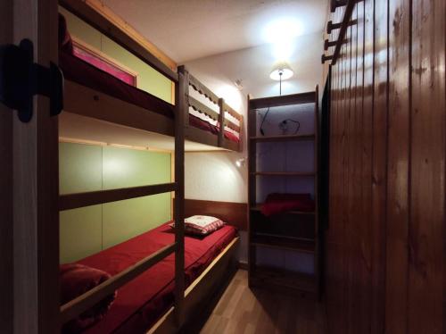 - une chambre avec 2 lits superposés et des draps rouges dans l'établissement Résidence Chamois - Studio pour 4 Personnes 154, à La Plagne Tarentaise