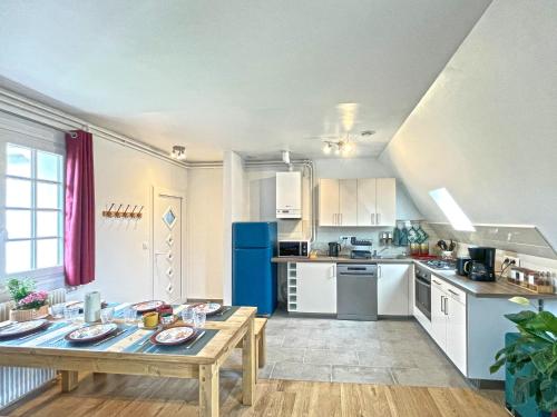 Il comprend une cuisine équipée d'une table et d'un réfrigérateur bleu. dans l'établissement Tropical Chill, à Saint-Martin-en-Bière