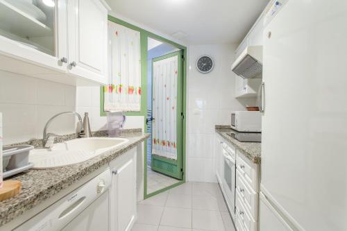 eine Küche mit weißen Schränken und einer grünen Tür in der Unterkunft Apartment Patacona Beach 7 in Valencia