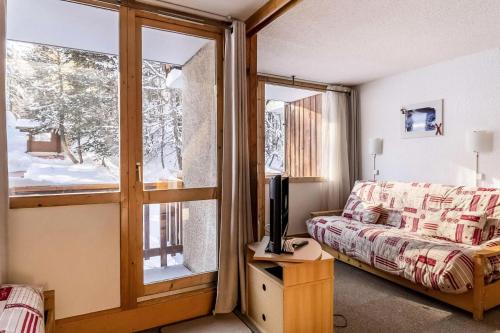 Cette chambre comprend un lit, une télévision et une fenêtre. dans l'établissement Résidence Les Soldanelles - Studio divisible 4 pers - LES SOLDANELLES - PLAGNE VILLAGES MAE-6054, à Aime La Plagne