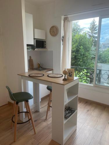 Elle comprend une petite cuisine avec un bureau et une fenêtre. dans l'établissement Studio à 5 min à pied de la mer, à Saint-Nazaire