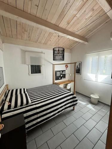 une chambre avec un grand lit avec un plafond en bois dans l'établissement Villa Malmont, à Draguignan