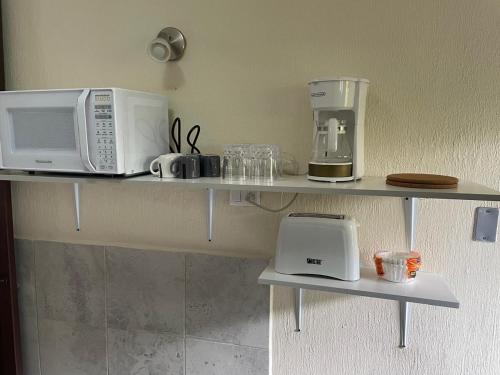 a shelf with two microwaves and appliances on it at Hogar Parroquia in Guatemala